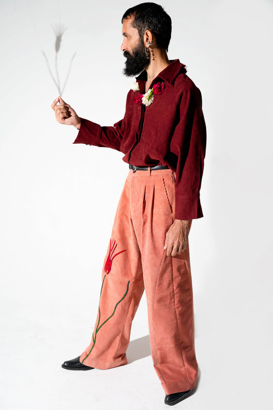 Unisex pants made with a mix of silk and pink corduroy, featuring a classic straight leg silhouette that is split in half.