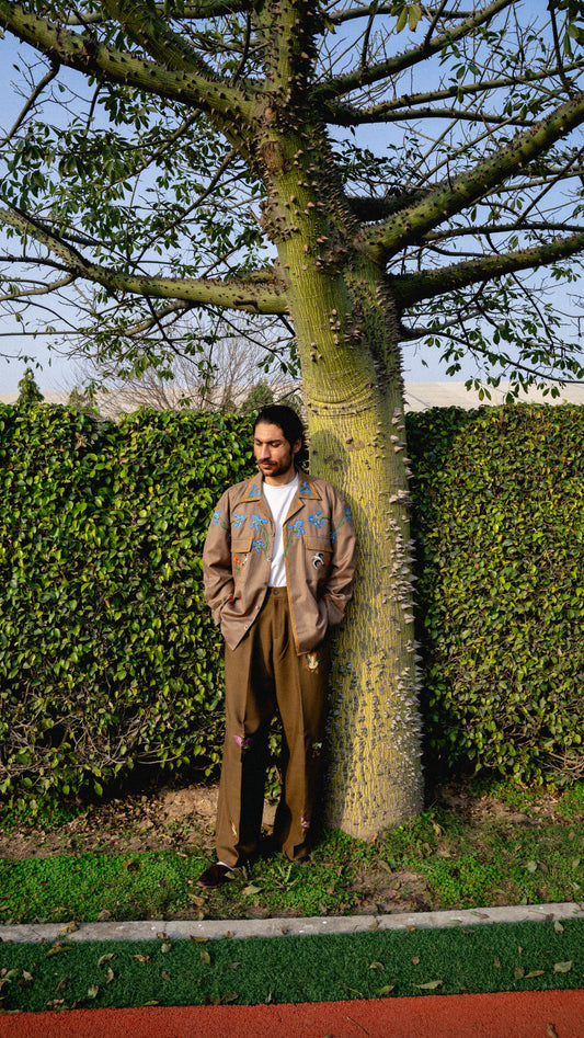 This lightweight shacket is crafted from a blended cotton and tropical fabric.