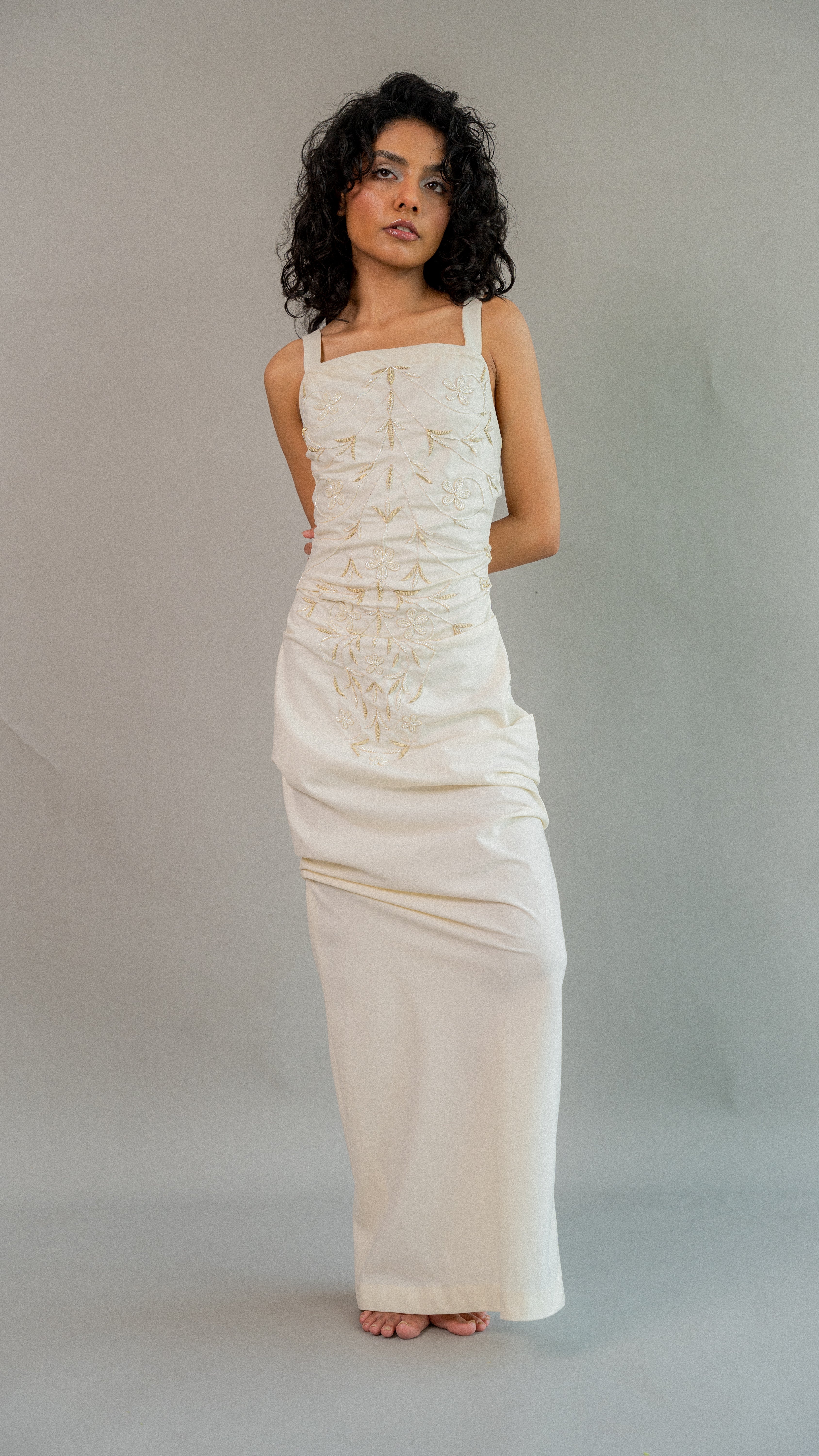 Woman wearing a white dress against a plain background