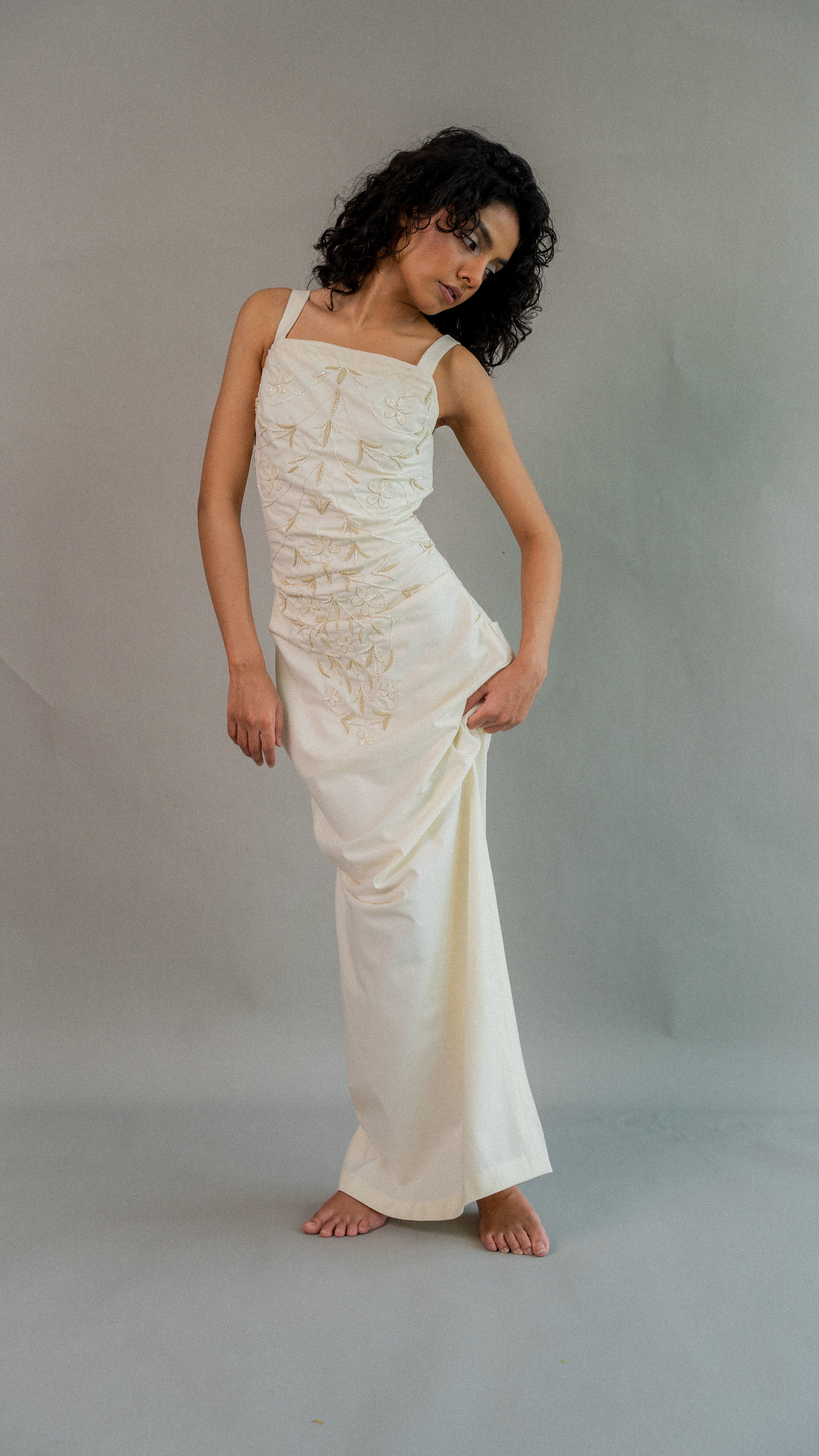 Woman wearing a white lace dress against a plain background