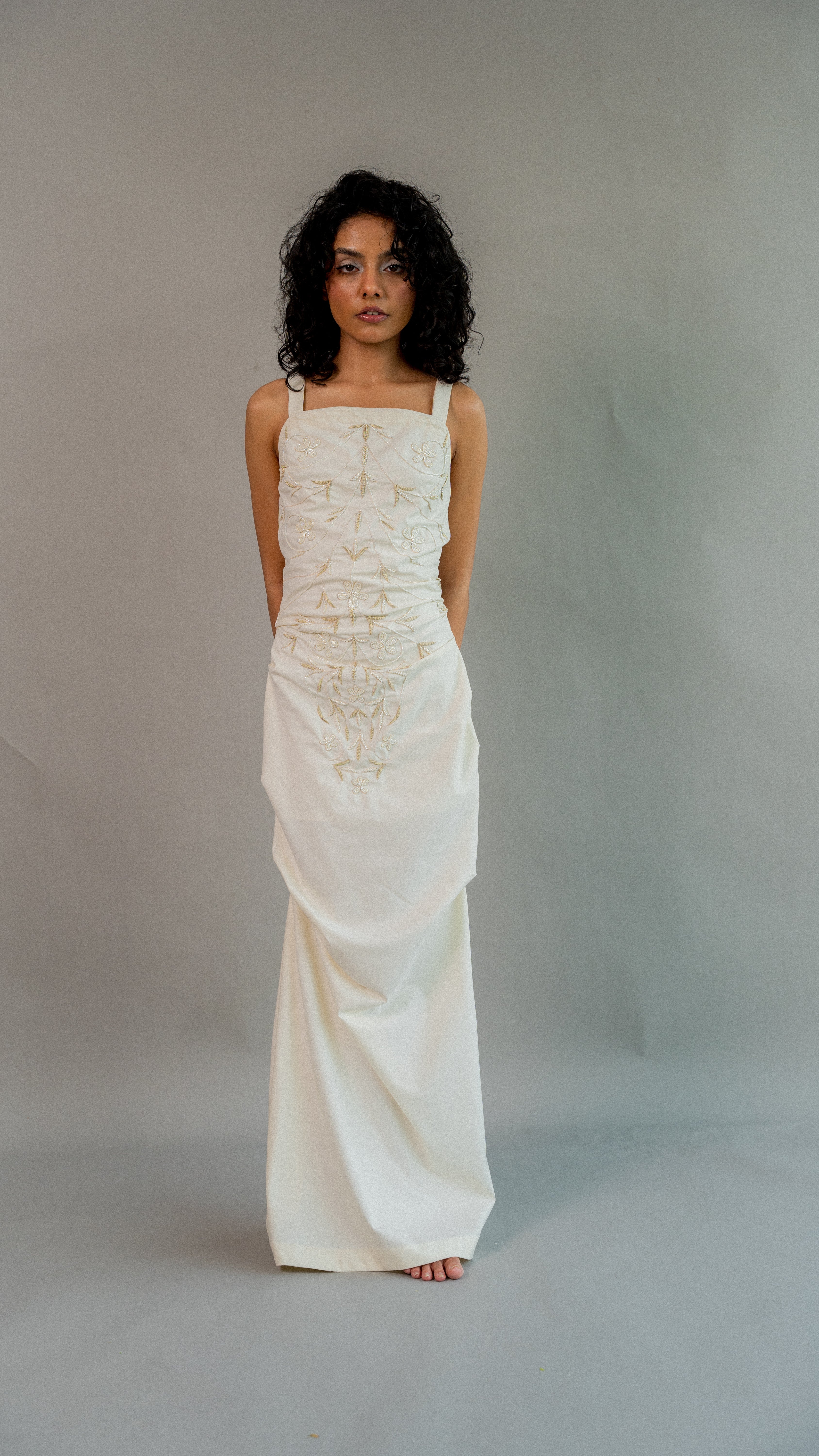 Woman wearing a white dress against a plain background
