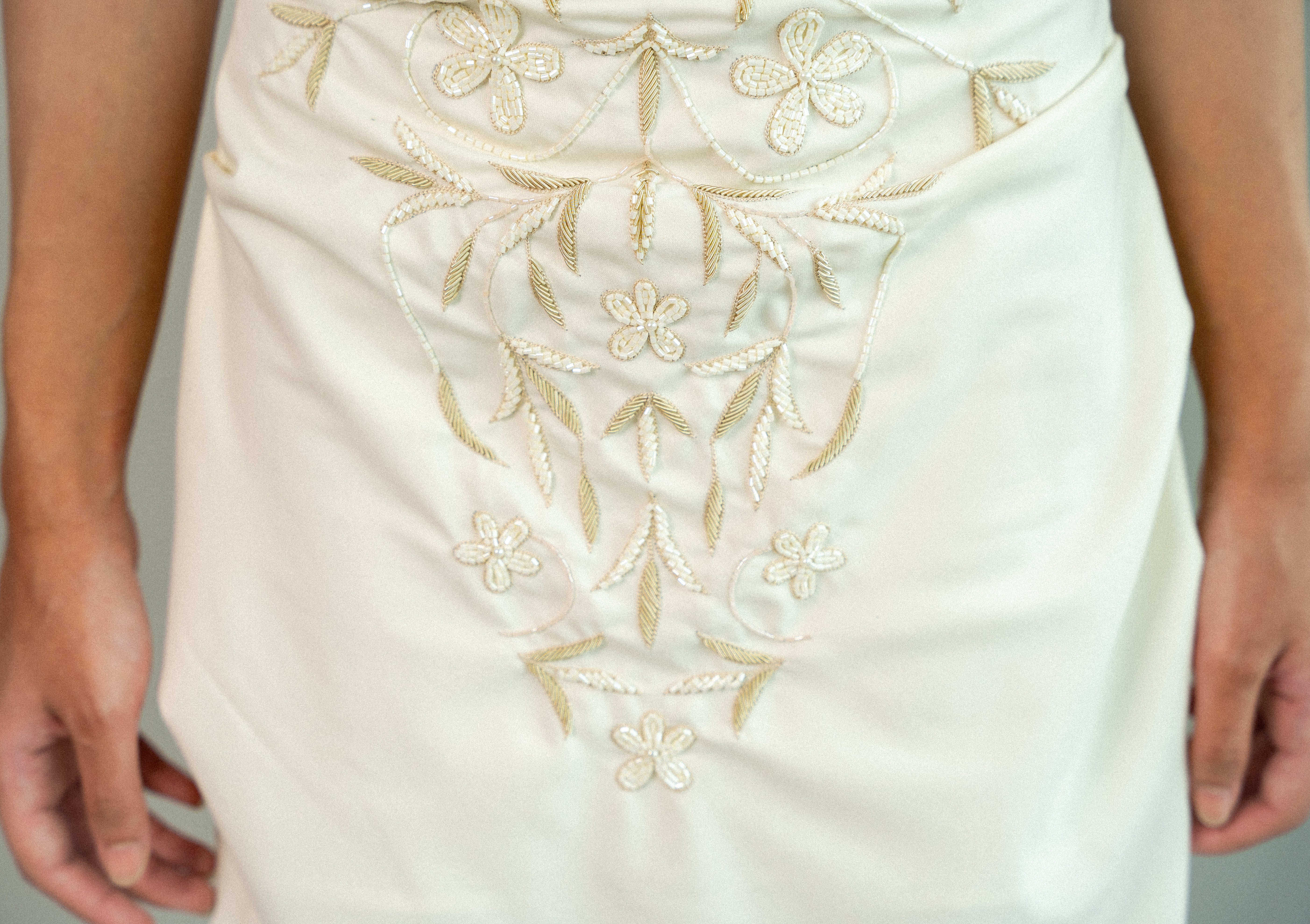 White garment with gold embroidery on a plain background