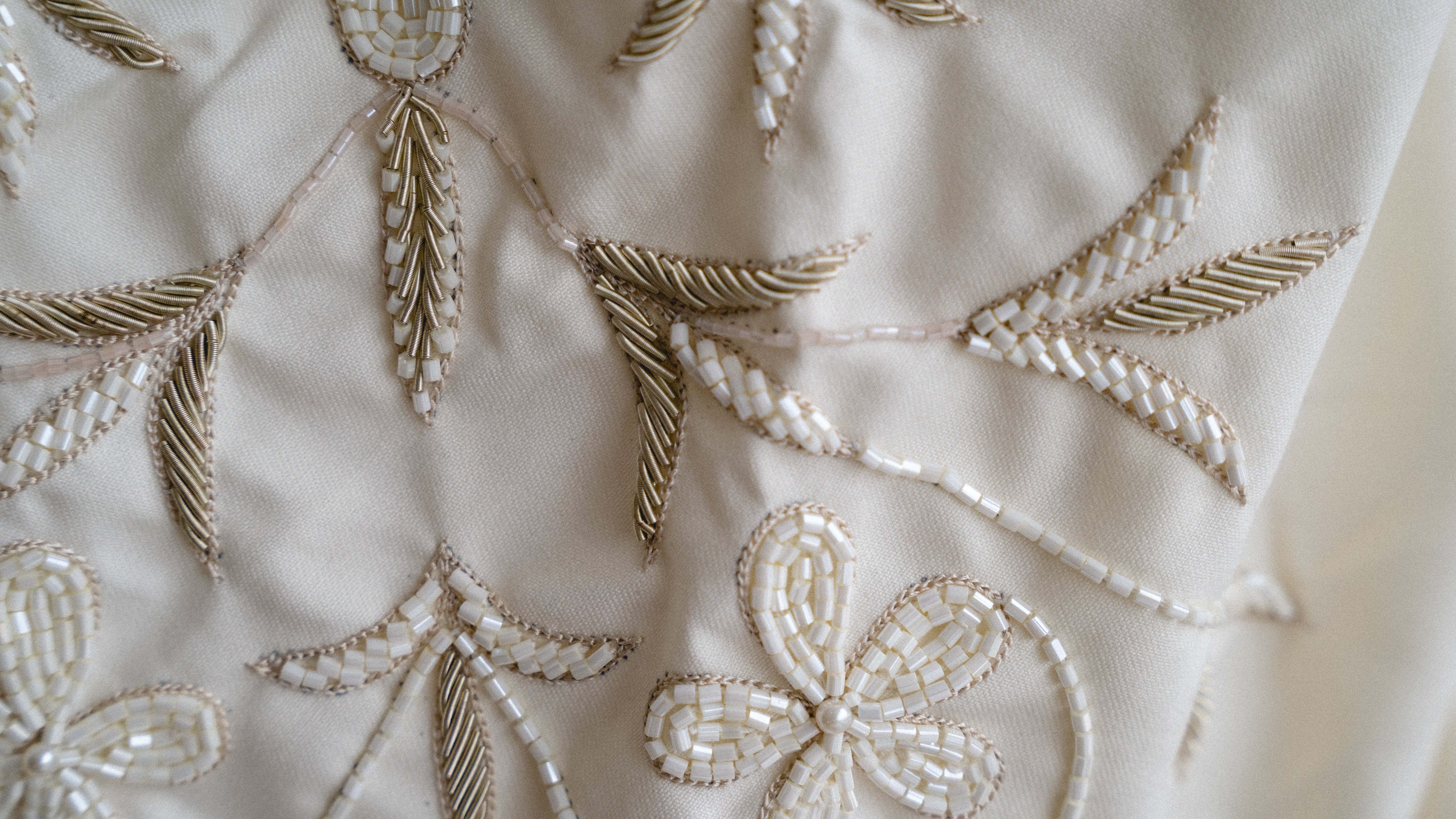 Close-up of intricate gold embroidery on a white fabric